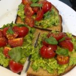 Smashed avocado on toast with cherry tomatoes