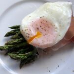 Poached egg served with asparagus and Parma ham